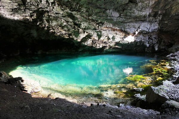 türkisfarben schimmerndes Wasser in einer Grotte